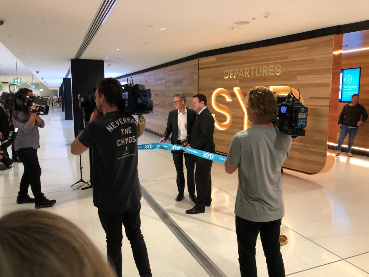 Featuring 25 metres of digital screen and a curved wall constructed from 10,000 lineal metres of Tasmanian Oak, the new @SydneyAirport departure farewell point has officially opened. Designed by HASSELL, it's a perfect backdrop to farewell visitors and travelling Sydneysiders. https://t.co/nUVdpqUGJc